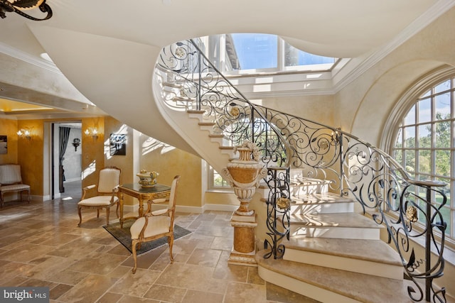 stairs featuring plenty of natural light, a skylight, and ornamental molding