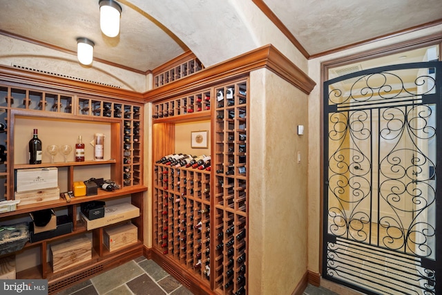 wine area featuring a textured ceiling and crown molding