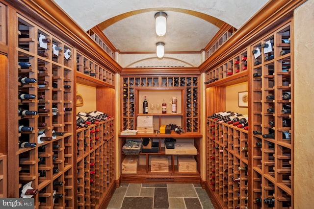 wine cellar with a textured ceiling and crown molding