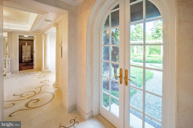 doorway featuring a tray ceiling, crown molding, light colored carpet, ornate columns, and french doors