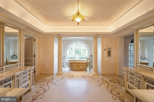 bathroom with a raised ceiling, ornate columns, and crown molding