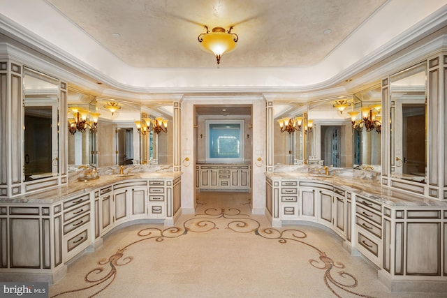 bathroom featuring ornamental molding, vanity, and a raised ceiling