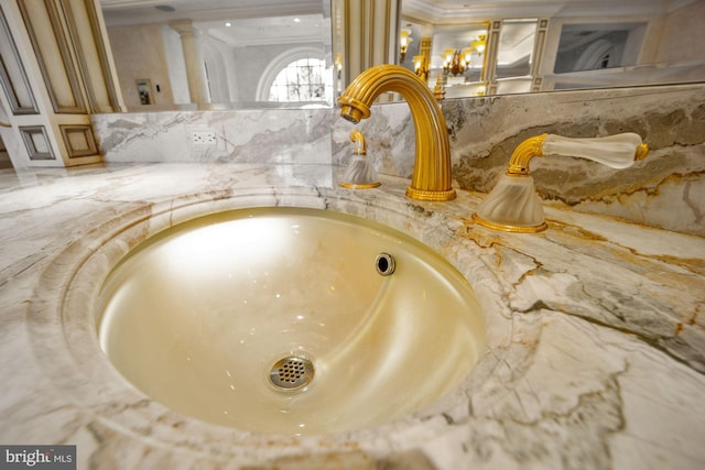 interior details with ornate columns, sink, and ornamental molding