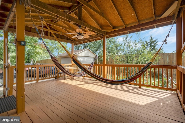 wooden deck with a storage unit and ceiling fan