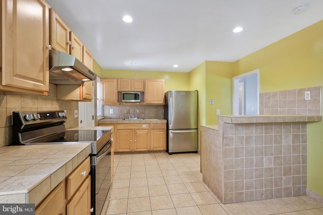 kitchen featuring light brown cabinets, sink, light tile patterned floors, and stainless steel appliances