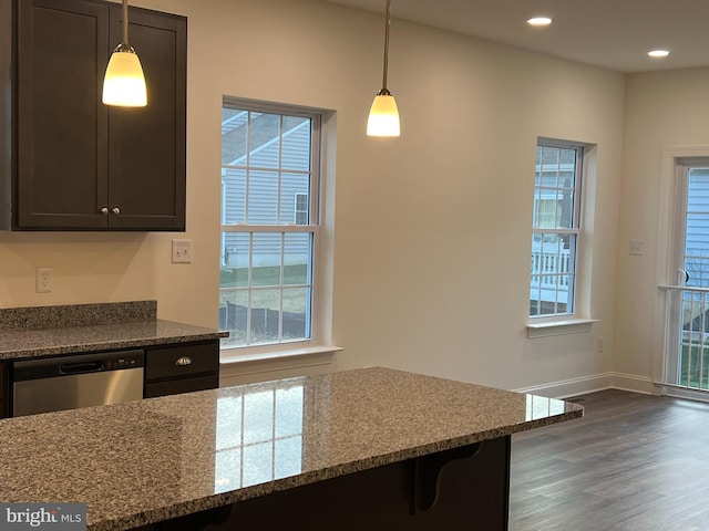 kitchen featuring dishwasher, dark hardwood / wood-style flooring, hanging light fixtures, and light stone countertops