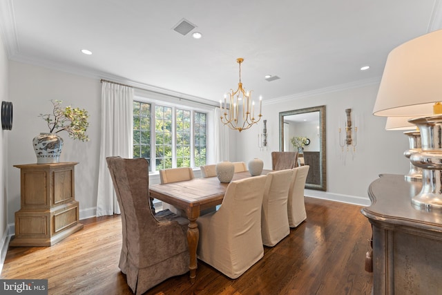 dining room featuring crown molding, wood-type flooring, and a notable chandelier