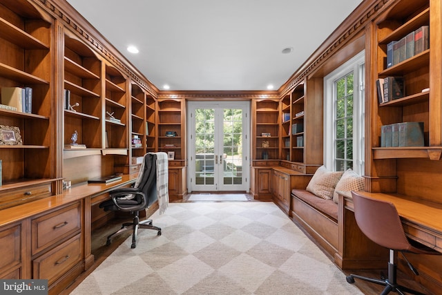 carpeted office space with crown molding, built in desk, and a healthy amount of sunlight