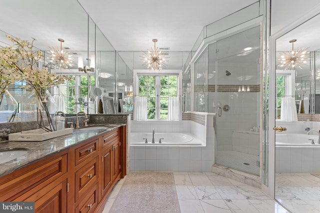 bathroom with vanity, shower with separate bathtub, and an inviting chandelier