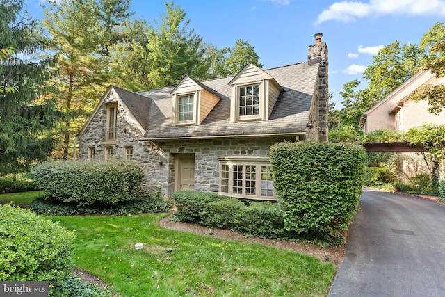 cape cod home featuring a front lawn