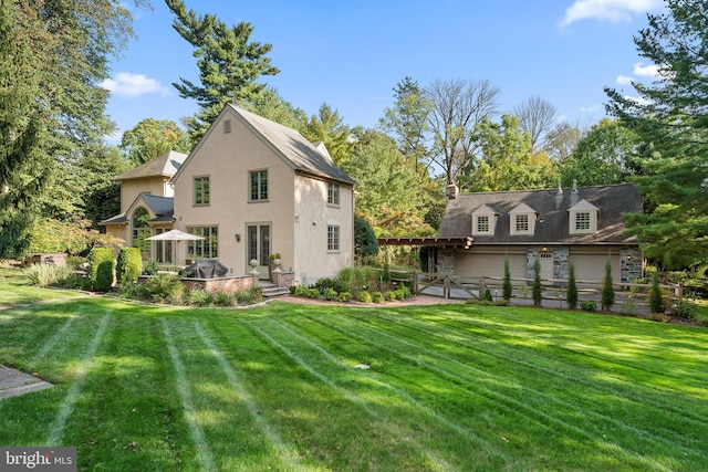 rear view of house featuring a yard