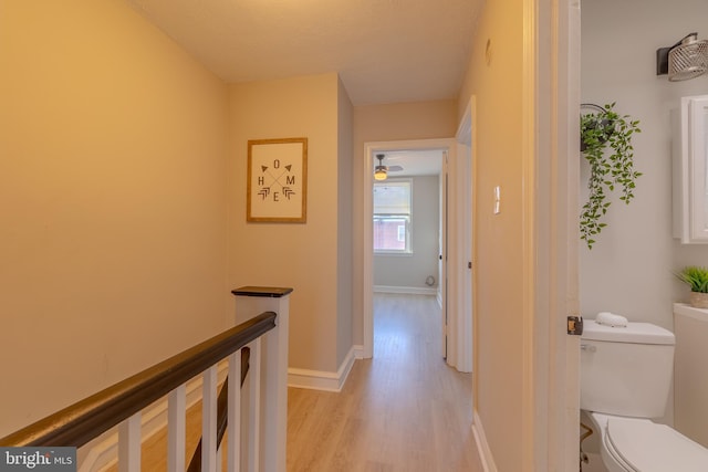 hall featuring a textured ceiling and light hardwood / wood-style floors