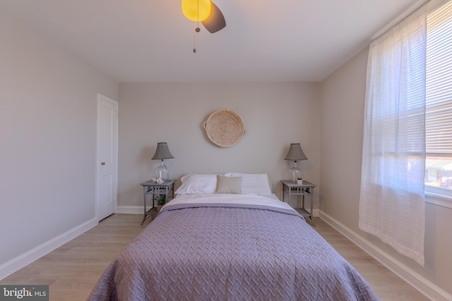 bedroom with ceiling fan, multiple windows, and light hardwood / wood-style floors