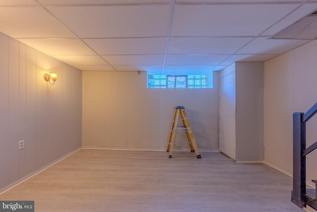 basement featuring a drop ceiling and hardwood / wood-style flooring