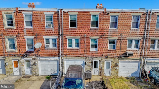 view of property featuring central air condition unit and a garage