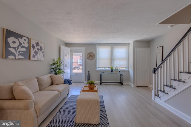 living room featuring a textured ceiling and light hardwood / wood-style flooring