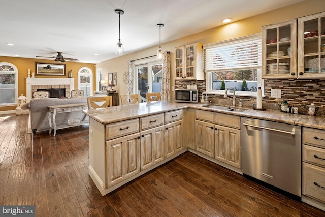 kitchen featuring dark hardwood / wood-style flooring, sink, pendant lighting, and appliances with stainless steel finishes