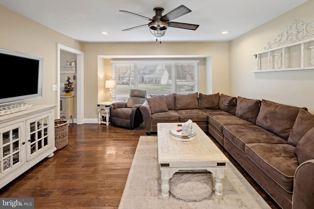 living room featuring ceiling fan and dark hardwood / wood-style floors