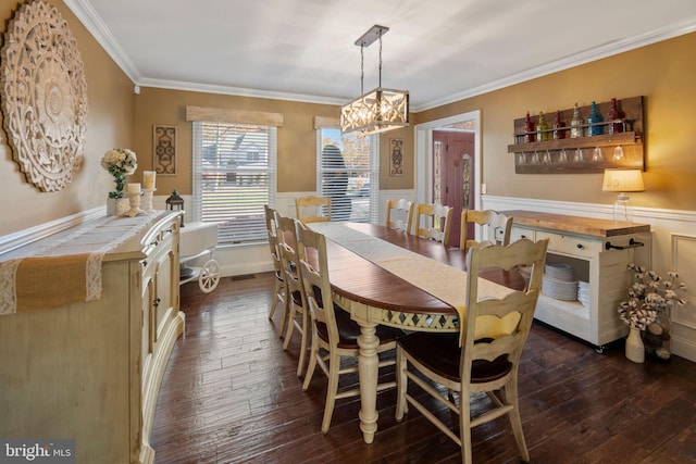 dining space featuring crown molding, an inviting chandelier, and dark hardwood / wood-style flooring