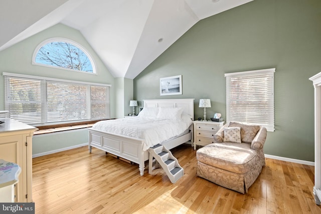 bedroom with high vaulted ceiling and light hardwood / wood-style floors