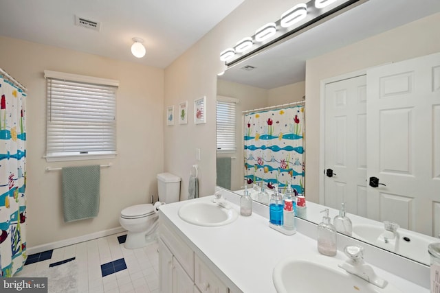 bathroom with tile patterned flooring, plenty of natural light, vanity, and toilet