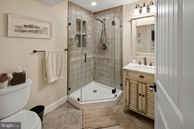 bathroom with toilet, vanity, tile patterned floors, and a shower with shower door