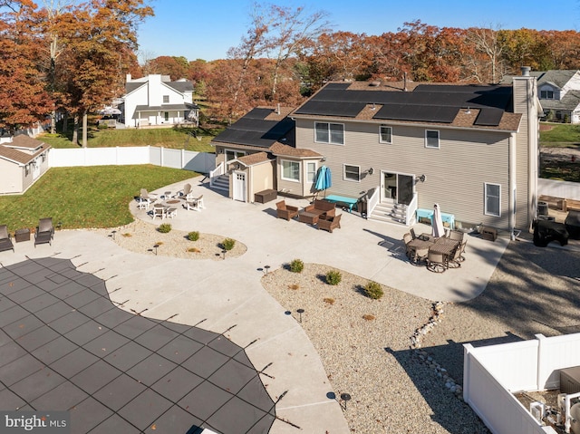 rear view of house featuring a patio area, solar panels, and a yard