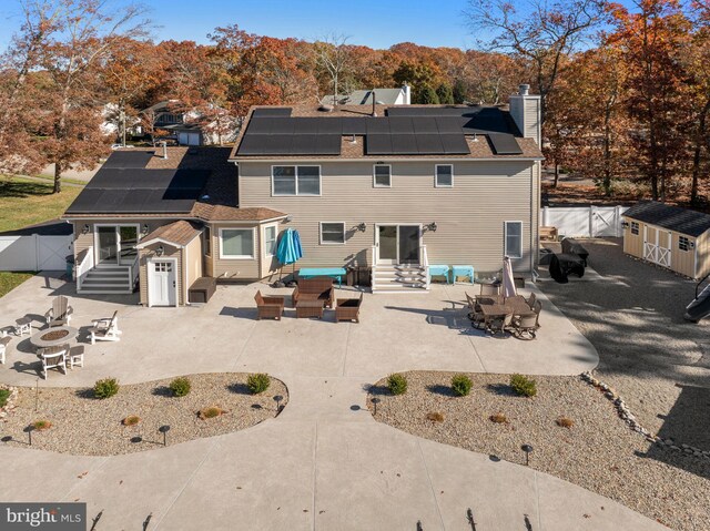 rear view of house featuring a storage unit and a patio