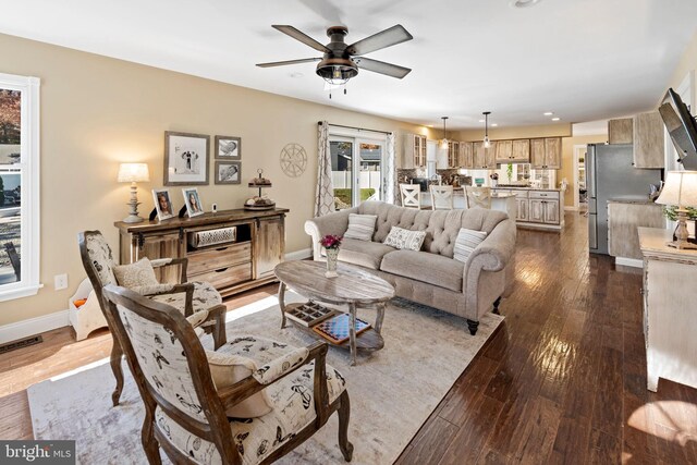 living room featuring ceiling fan and dark hardwood / wood-style flooring