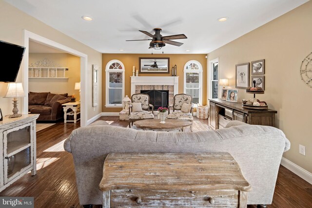 living room featuring dark wood-type flooring and ceiling fan