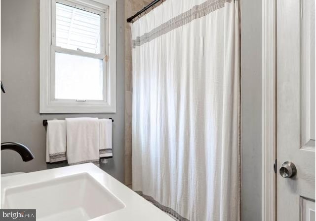 bathroom featuring curtained shower and sink