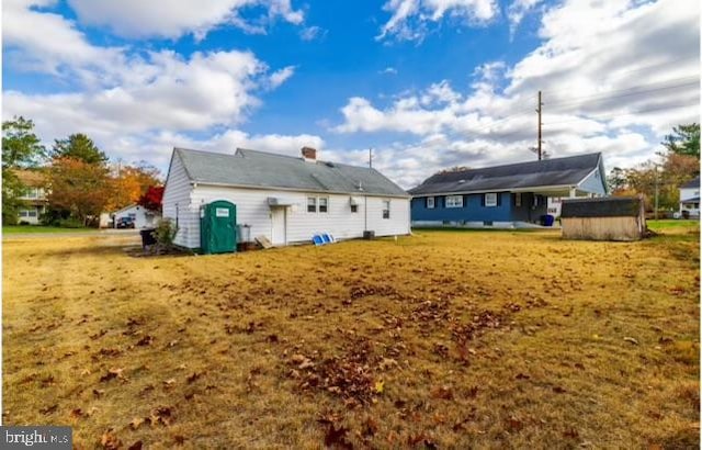 rear view of house with a storage shed