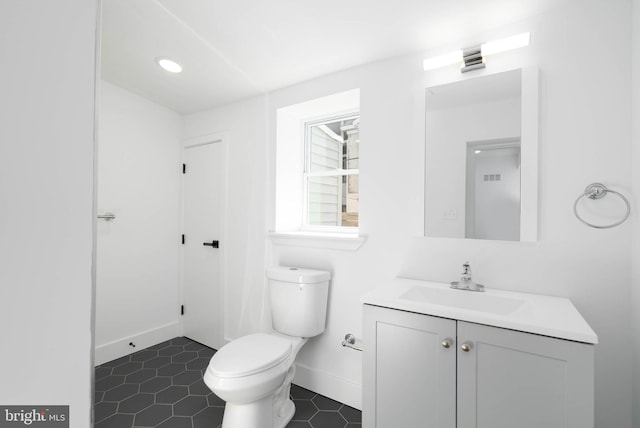 bathroom featuring toilet, vanity, and tile patterned flooring