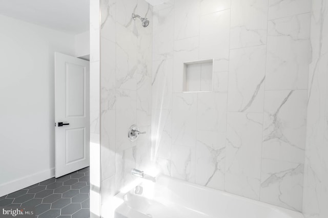 bathroom with tiled shower / bath combo and tile patterned flooring