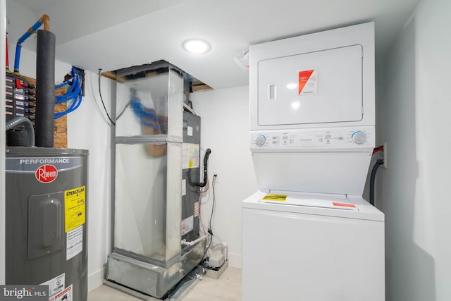 washroom featuring stacked washer / drying machine and electric water heater