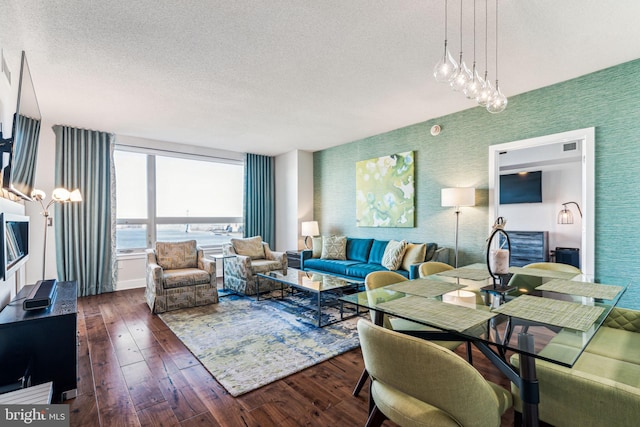 living room featuring a textured ceiling, a water view, and dark wood-type flooring