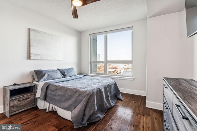 bedroom featuring ceiling fan, dark hardwood / wood-style flooring, and a textured ceiling