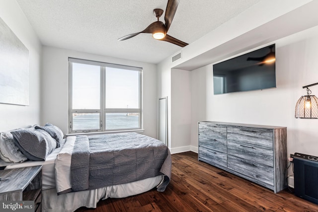 bedroom with ceiling fan, dark hardwood / wood-style flooring, radiator heating unit, and a textured ceiling