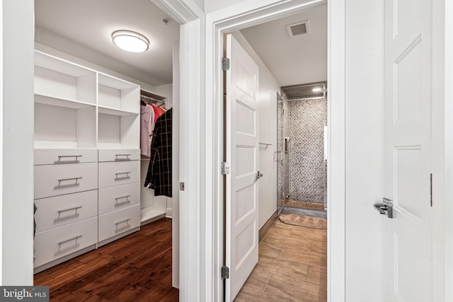 walk in closet with hardwood / wood-style floors