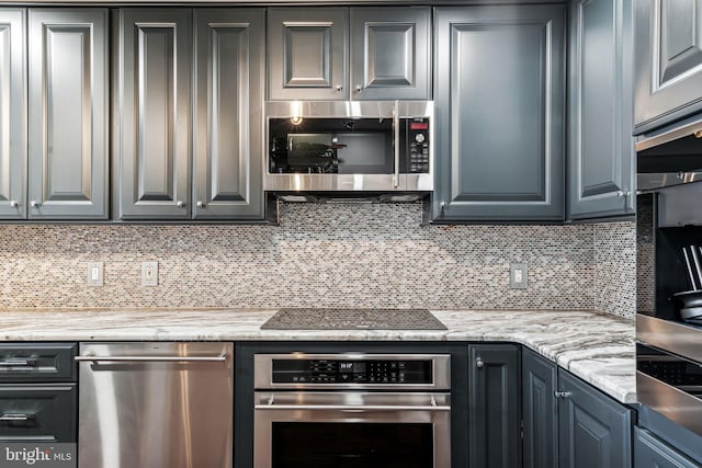 kitchen featuring tasteful backsplash, light stone countertops, and stainless steel appliances