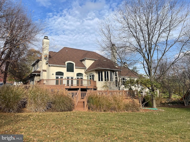 rear view of property featuring a lawn and a wooden deck