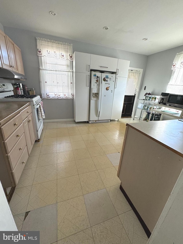 kitchen with light brown cabinetry and white appliances