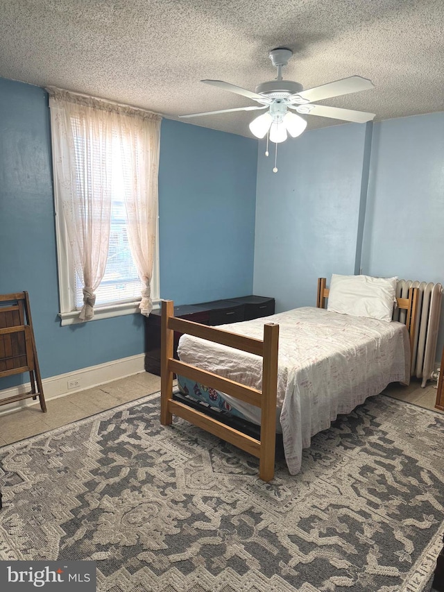 carpeted bedroom featuring radiator heating unit, a textured ceiling, and ceiling fan