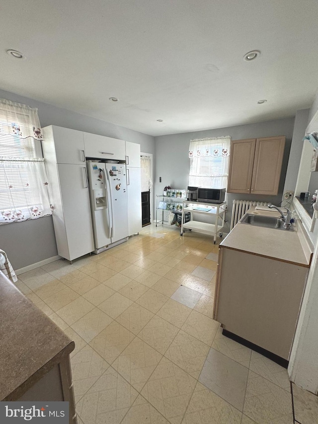 kitchen with sink and white refrigerator with ice dispenser