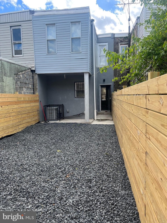 rear view of house with a fenced backyard and a patio area