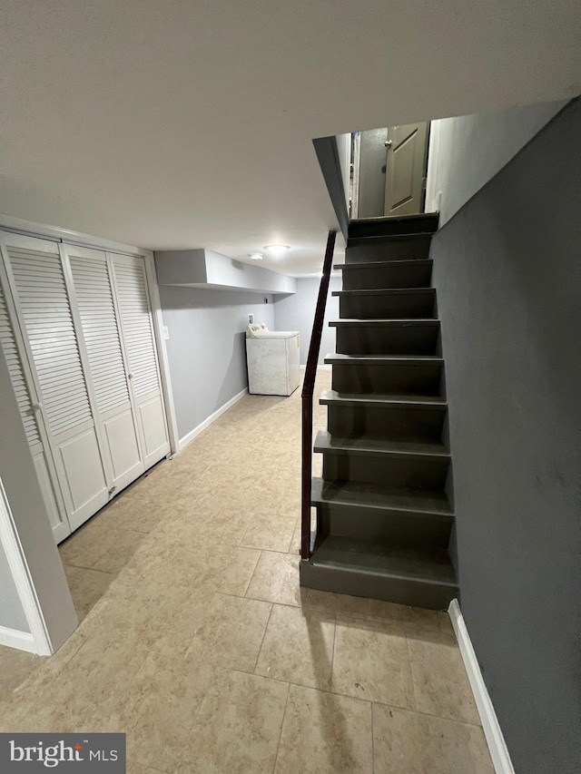 stairway with tile patterned flooring and washer / dryer