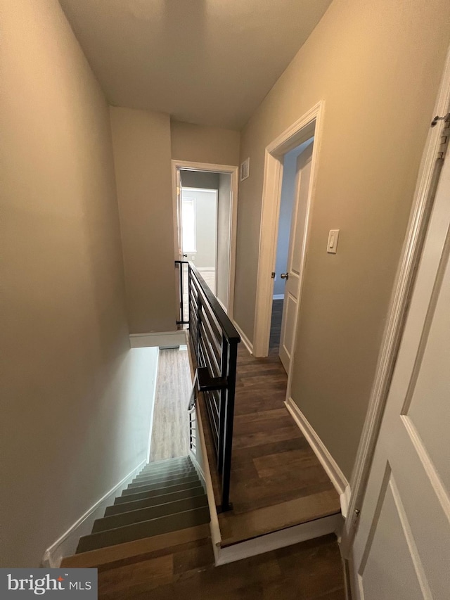stairway featuring wood finished floors and baseboards