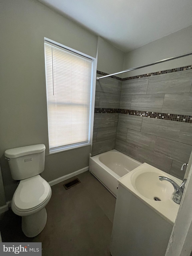 full bathroom featuring a wealth of natural light, vanity, tiled shower / bath combo, and toilet