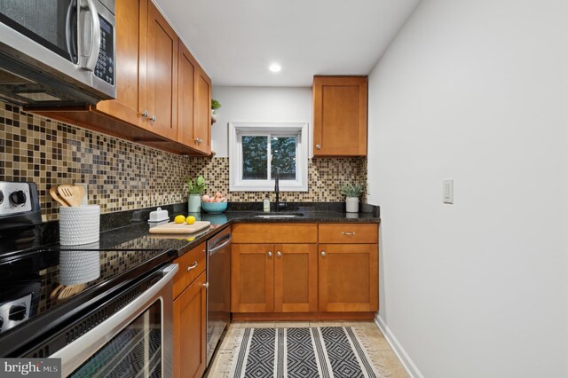 kitchen featuring backsplash, appliances with stainless steel finishes, and sink