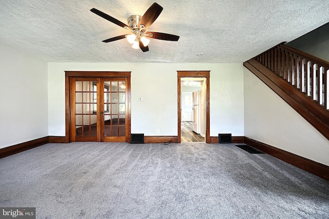 empty room featuring ceiling fan, a textured ceiling, carpet flooring, and french doors